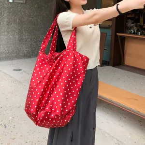 Λεπτομέρεια τσάντας tote με κόκκινες βούλες, casual υφασμάτινη τσάντα ώμου για καθημερινή χρήση.