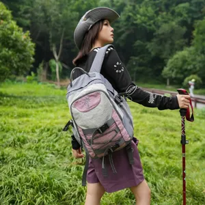 Vista detallada de la mochila de viaje gris y rosa para exteriores llevada por un modelo.