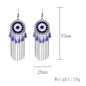 Vista detallada de pendientes colgantes de metal vintage bohemio con flecos y estrás.