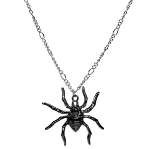 Primer plano detallado de un collar con colgante de araña negra con cadena plateada.
