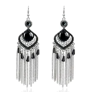 Primer plano de pendientes vintage plateados con cuentas negras y largas cadenas colgantes.