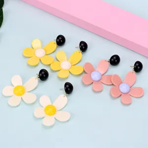 Detallado primer plano de pendientes colgantes de acrílico con bonito diseño de flor.