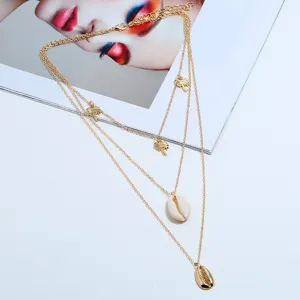 Exquisito collar dorado multicapa con encantadores colgantes de palmera y concha elegantes.