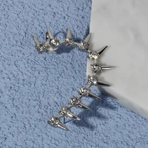 Gedetailleerde close-up van punk oorclip met zilveren klinknagels en strass, gothic sieraad.