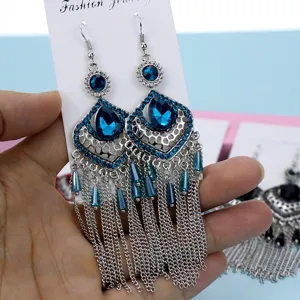 Primer plano detallado de pendientes largos vintage de diamantes de imitación azules.