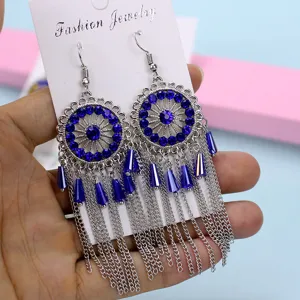Pendientes colgantes bohemios plateados con pedrería azul y detalles metálicos finos.