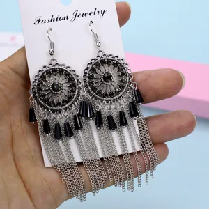 Pendientes largos con flecos y pedrería plateada estilo bohemio vintage detalle.