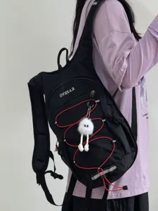 Sac à dos de sport en plein air noir avec cordons élastiques rouges et porte-clés en peluche mignon.