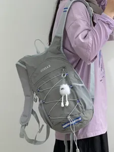 Vue détaillée du sac à dos d'extérieur gris léger avec cordons élastiques et joli pendentif.