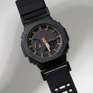Detail view of the black octagonal quartz watch featuring gold indices and digital display.