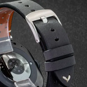 Leather watch strap detail showing stainless steel buckle and breathable perforated design.
