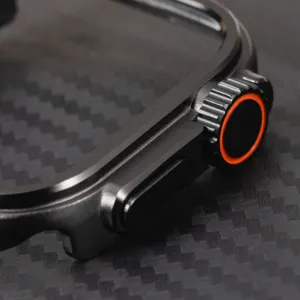 Detailed close-up view of black metal protective watch case with orange crown accent.