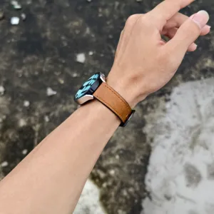 Dettaglio cinturino in pelle marrone, con fibbia in acciaio e perno a sgancio rapido.