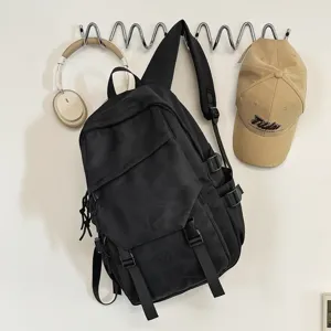 Detailansicht eines stylischen schwarzen Rucksacks mit Accessoires an der Wandhaken.