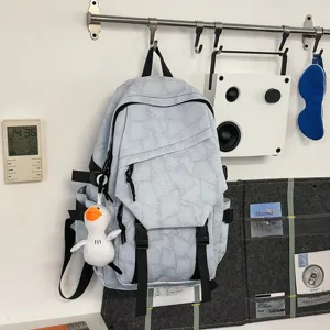 Nahaufnahme eines hellblauen geometrischen Rucksacks an der Wand mit Entenanhänger.