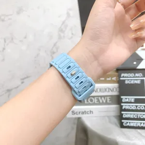 Primo piano di un cinturino per orologio in silicone azzurro al polso con maglie strutturate.