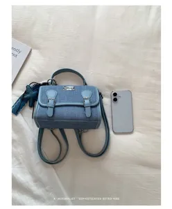 Zaino mini in denim azzurro chiaro chic con doppie cinghie, manico e ciondolo a stella marina.
