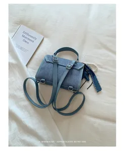 Dettaglio ravvicinato del trendy zaino in denim con fibbie metalliche rifinite e ottima texture.