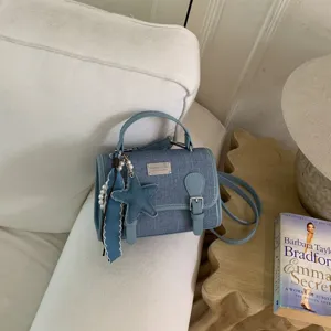 Elegante borsa a tracolla in denim blu con ciondolo a stella e perle per donne chic.