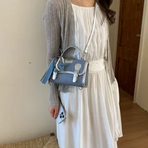 Borsa a tracolla da donna in denim elegante con bordo argentato e grazioso ciondolo.