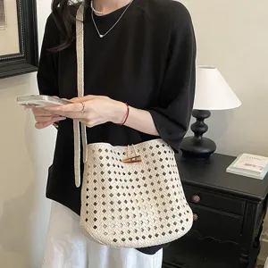 Dettaglio della borsa a secchiello intrecciata chic con design traforato per look casual.