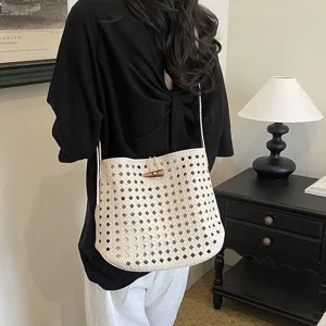 Primo piano della borsa a spalla intrecciata chic con chiusura in legno elegante.