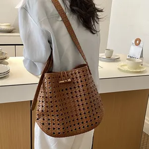 Vista dettagliata di elegante borsa a secchiello in pelle intrecciata marrone con chiusura.