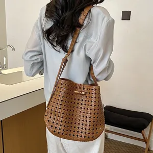 Primo piano della borsa a spalla in pelle intrecciata marrone, con texture e stile chic.