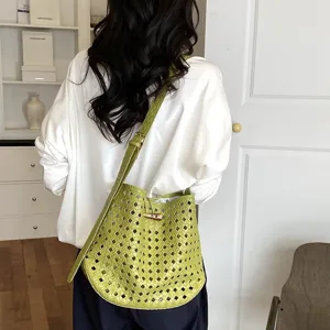 Vista dettagliata della borsa a spalla in pelle intrecciata verde con lavorazione raffinata.