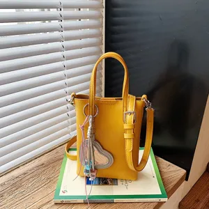 Yellow mini vertical shoulder phone bag with heart pendant daily commuting casual chic tote.