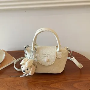 Borsa a secchiello chic in pelle crema con ciondolo cucciolo di peluche per tutti i giorni.