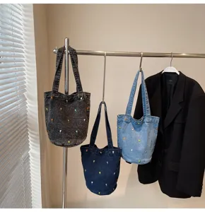 Vue détaillée du sac seau en denim brodé chic, avec des motifs floraux et un style tendance.