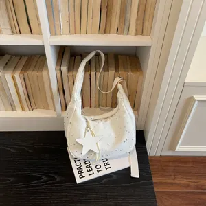 Vista ravvicinata e dettagliata della borsa hobo bianca con stampa a stelle e charm con stella.