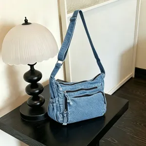 Λεπτομερης εικονα vintage τσαντας ωμου απο denim με πολλες πρακτικες θηκες και φερμουαρ