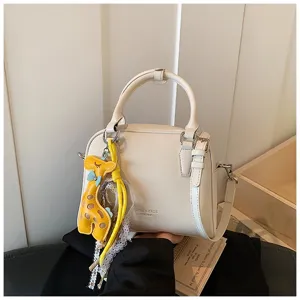 White crossbody small square bag detail, elegant commuter shoulder bag with cute giraffe charm.