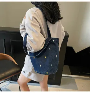 Sac seau en denim élégant avec broderie délicate de tulipes, idéal pour le quotidien.