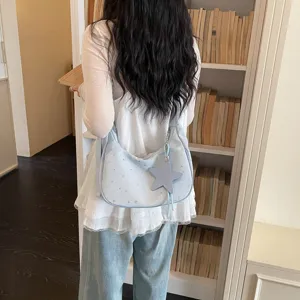 Borsa a tracolla casual azzurro chiaro con stampa di stelle e ciondolo a stella in dettaglio.