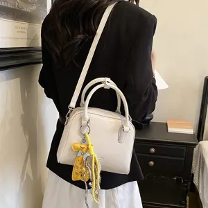 Chic minimalist white shoulder crossbody bag with cute giraffe charm for daily commute.
