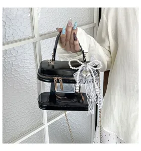 Bolso de mano de PVC transparente con lazo de encaje de perlas y cadena metálica.