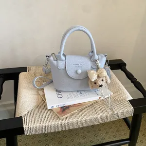 Borsa a secchiello chic in pelle azzurra con ciondolo cucciolo carino per l'uso quotidiano.