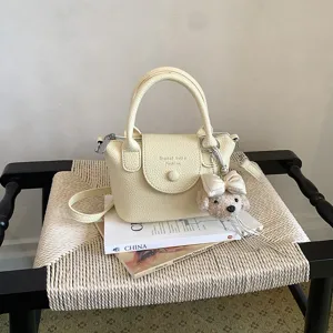 Elegante borsa a secchiello in pelle PU gialla con manico e simpatico ciondolo cane in peluche.