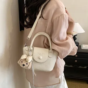 Elegante borsa a secchiello da donna con ciondolo cucciolo, borsa a tracolla in pelle.