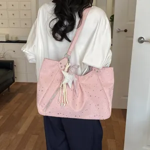 Detailed back view of a pink star print shoulder tote bag with cute star charm accessory.