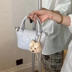 Elegante borsa a secchiello in pelle azzurra con grazioso ciondolo orsetto, borsa chic.