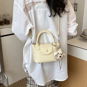 Piccola borsa a secchiello gialla da donna, elegante borsa a tracolla con ciondolo.