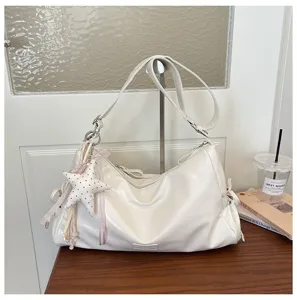 Détail de sac porté épaule blanc en similicuir élégant avec pendentif étoile mignon.