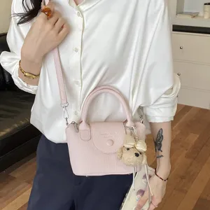 Vista dettagliata della borsa mini in pelle rosa con ciondolo, elegante e pratica.