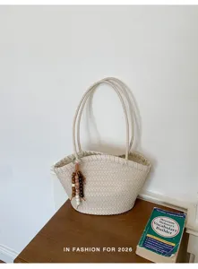 Nahaufnahme der eleganten geflochtenen Ledertasche mit stilvollem Perlenanhänger.
