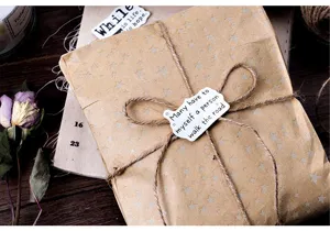 Detailed shot of decorative journal stickers packaging with vintage brown paper and twine.