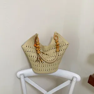 Schicke beige Lochmuster Tote Tasche mit stilvollen Holzperlen Griffdetails für den Sommer.